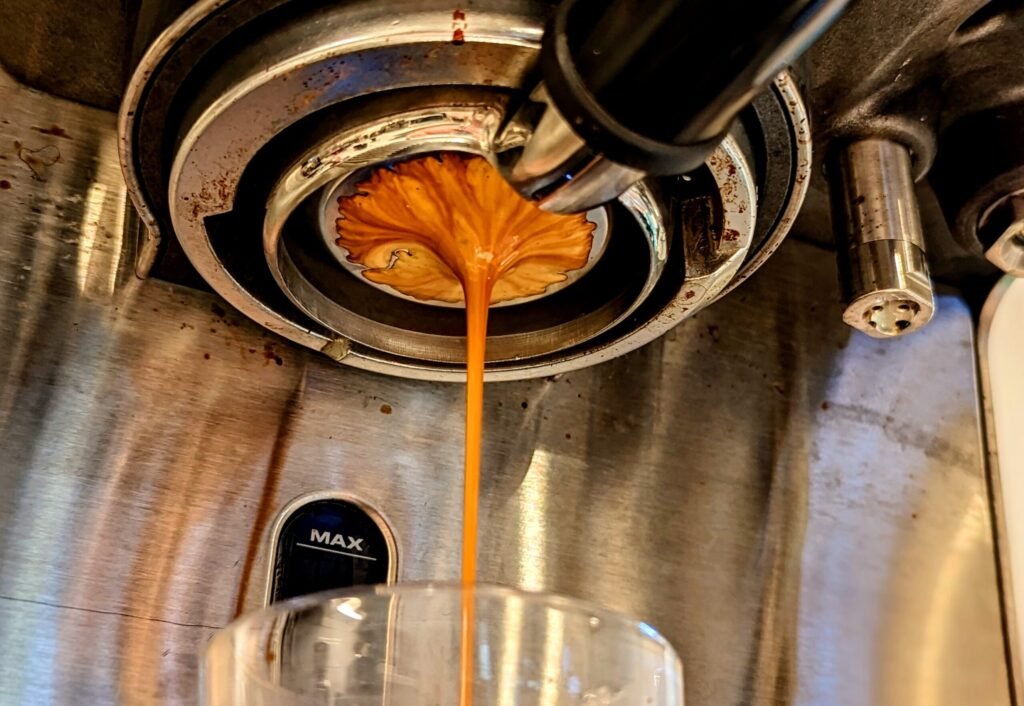 An espresso shot pulling into a small cup